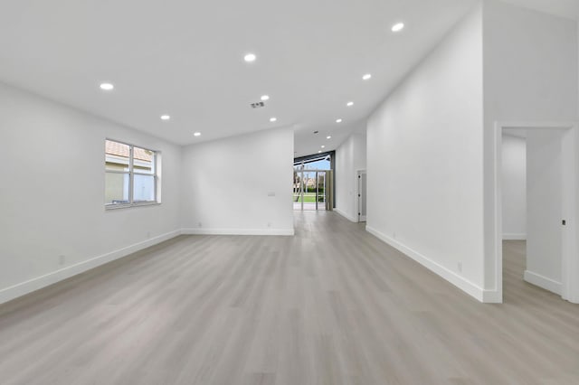 empty room featuring recessed lighting, light wood-style floors, and plenty of natural light
