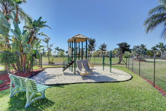 community playground featuring a yard and fence