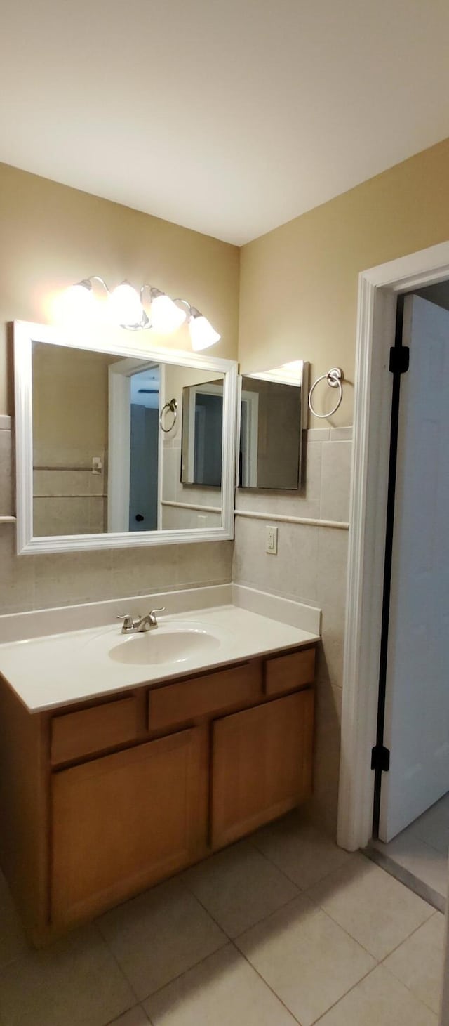 bathroom with tile walls, tile patterned flooring, and vanity