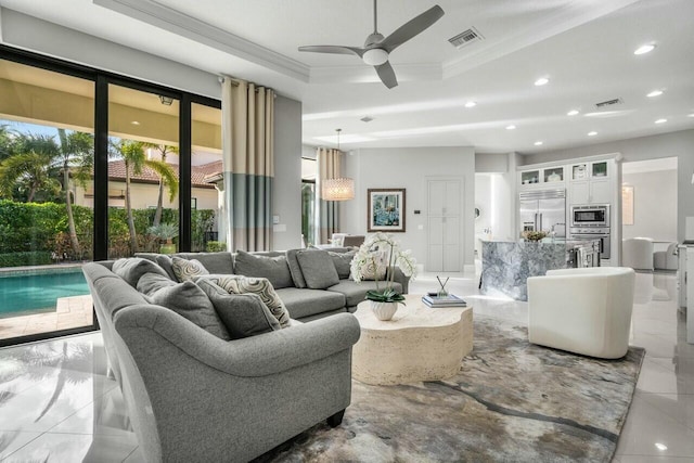 living room featuring a raised ceiling, crown molding, a ceiling fan, and visible vents