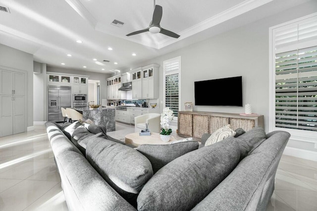 living area featuring recessed lighting, crown molding, visible vents, a tray ceiling, and ceiling fan