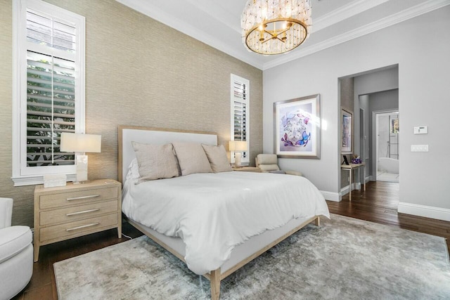 bedroom featuring baseboards, a raised ceiling, an inviting chandelier, ornamental molding, and wood finished floors