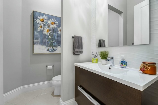 bathroom featuring toilet, vanity, baseboards, and tile patterned flooring