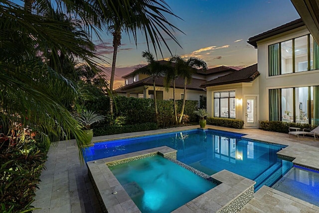 view of swimming pool featuring a pool with connected hot tub and a patio area