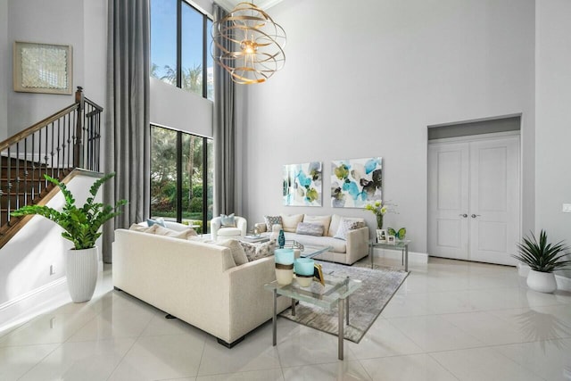 tiled living area with baseboards, stairway, a chandelier, and a towering ceiling