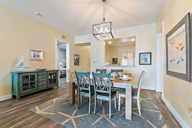 dining space with a chandelier, baseboards, visible vents, and dark wood-style floors