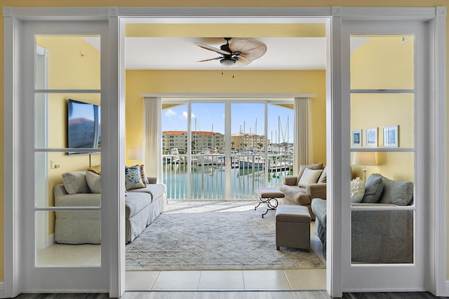 interior space featuring tile patterned floors, a ceiling fan, and a water view