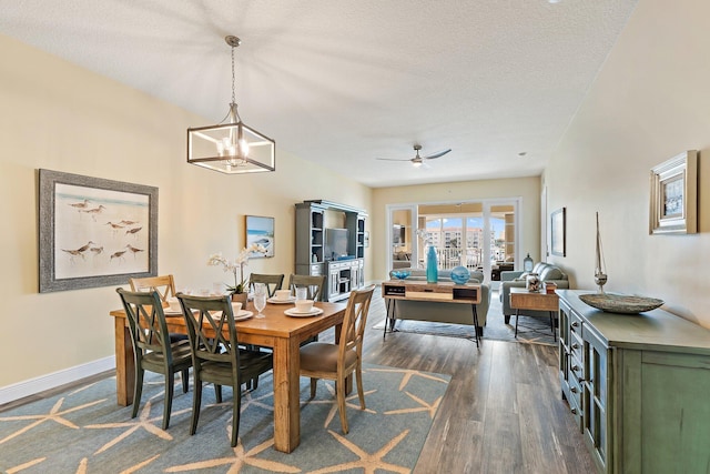 dining room with ceiling fan, baseboards, a textured ceiling, and dark wood-style floors