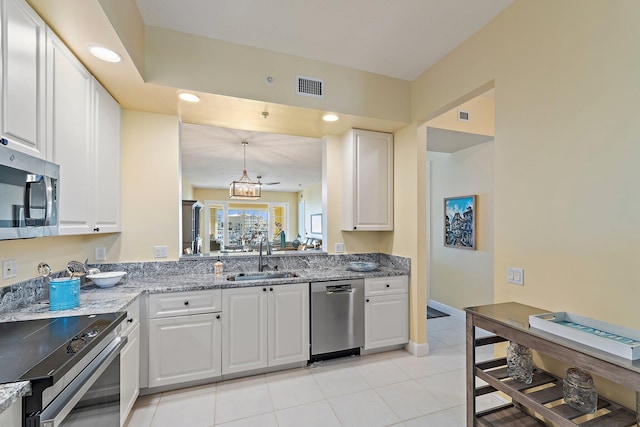 kitchen with a sink, stainless steel appliances, white cabinetry, a notable chandelier, and visible vents