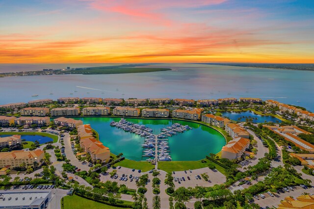 aerial view at dusk featuring a water view