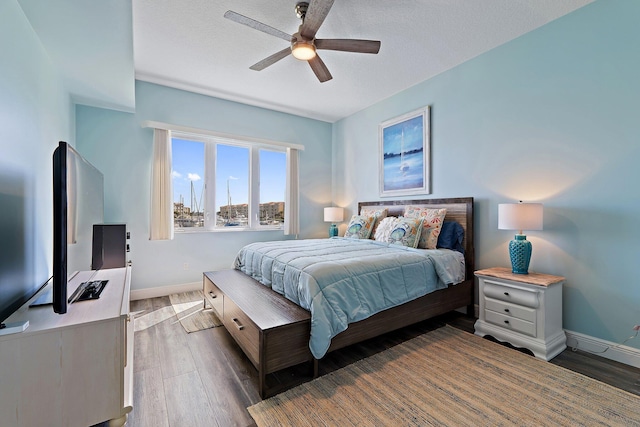 bedroom with wood finished floors, a ceiling fan, and baseboards