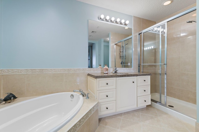 full bathroom with a shower stall, a garden tub, tile patterned flooring, and vanity