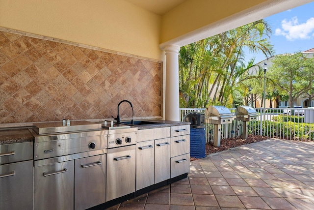 view of patio / terrace with exterior kitchen, grilling area, a sink, and fence