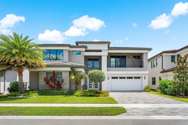 view of front of property with a balcony, a garage, stucco siding, and decorative driveway