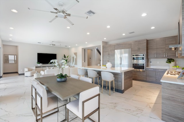 dining room with a ceiling fan, recessed lighting, and light marble finish floors