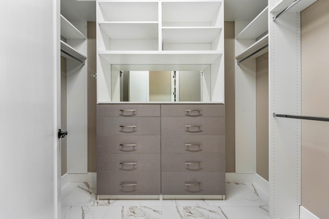 walk in closet with marble finish flooring