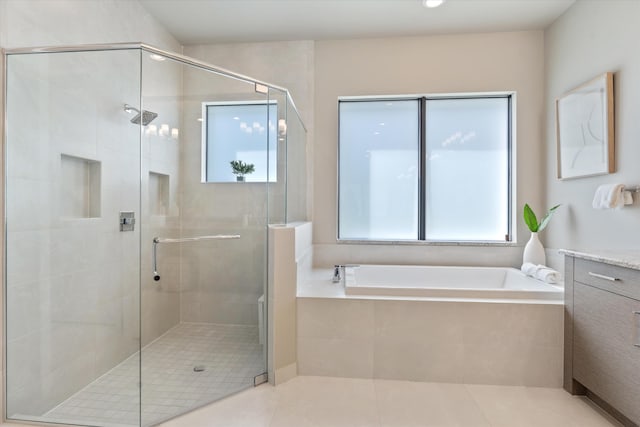 full bathroom with a garden tub, a shower stall, tile patterned flooring, and vanity