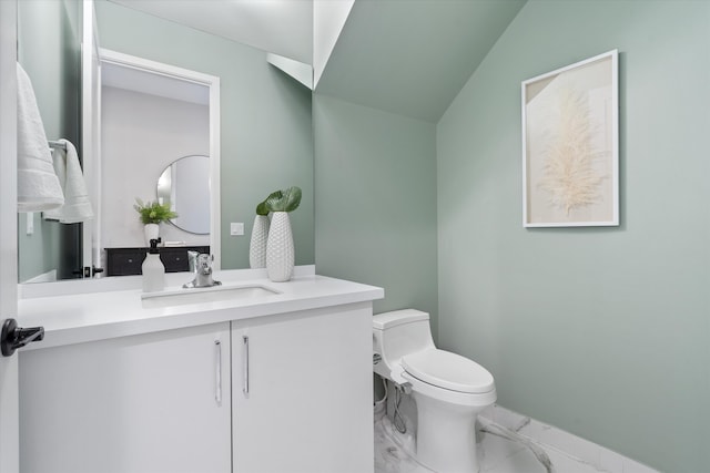 bathroom with marble look tile flooring, toilet, and vanity