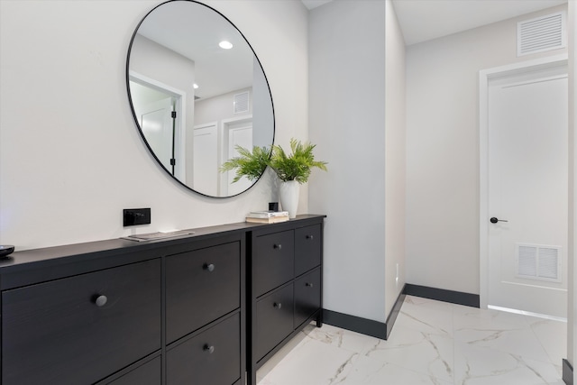 bathroom with baseboards, marble look tiles, and vanity