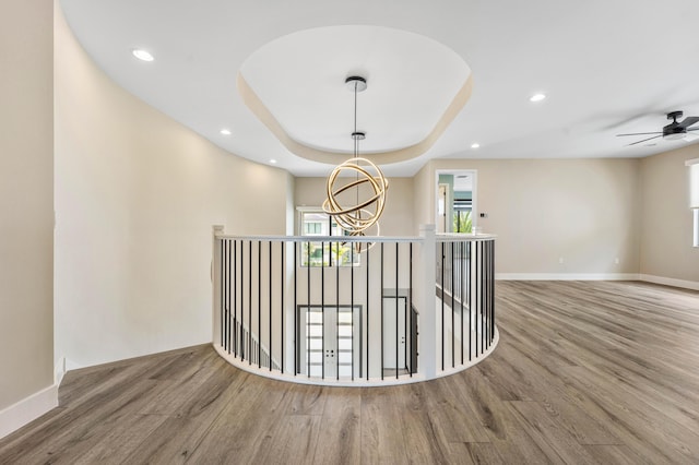 hallway featuring wood finished floors, a chandelier, healthy amount of natural light, and recessed lighting