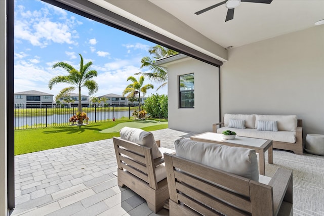 view of patio / terrace featuring a water view, an outdoor living space, ceiling fan, and a residential view