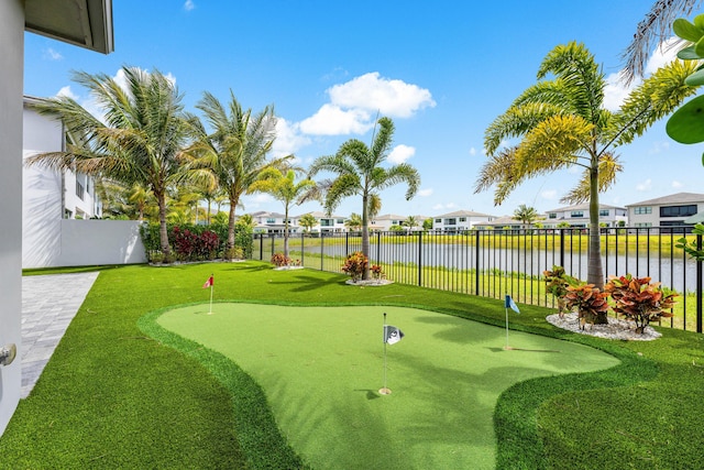 surrounding community featuring fence, a residential view, a water view, and an area to practice putting