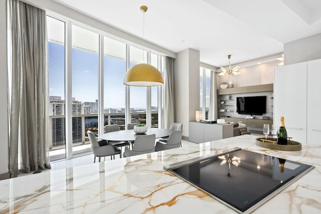 kitchen featuring marble finish floor, pendant lighting, and light stone counters
