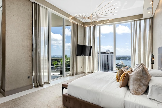 bedroom with a wall of windows, multiple windows, and an inviting chandelier
