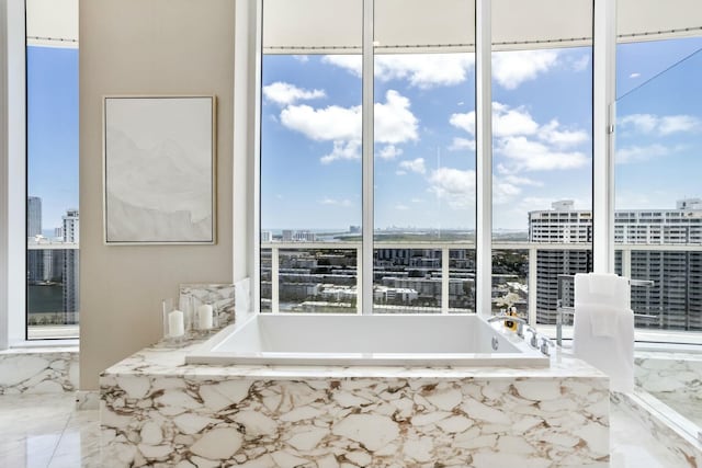 interior space featuring marble finish floor, a garden tub, and a view of city