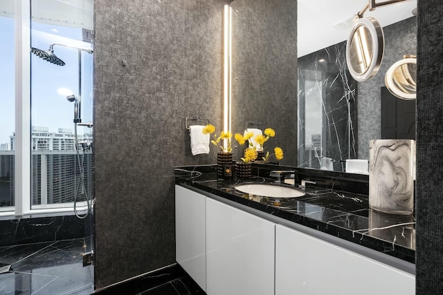 full bathroom with a city view, a shower stall, vanity, marble finish floor, and tile walls
