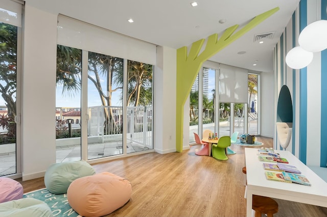 playroom featuring visible vents, baseboards, and wood finished floors