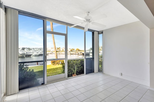 21 Yacht Club Dr Unit 102, North Palm Beach, FL 33408 - tiled spare room with ceiling fan, a wall of windows, and a water view