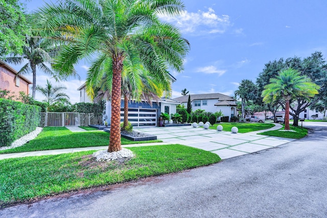 view of front facade featuring fence, concrete driveway, and a front yard