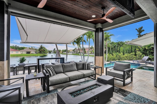 view of patio with a water view, a ceiling fan, an outdoor pool, and an outdoor living space with a fire pit