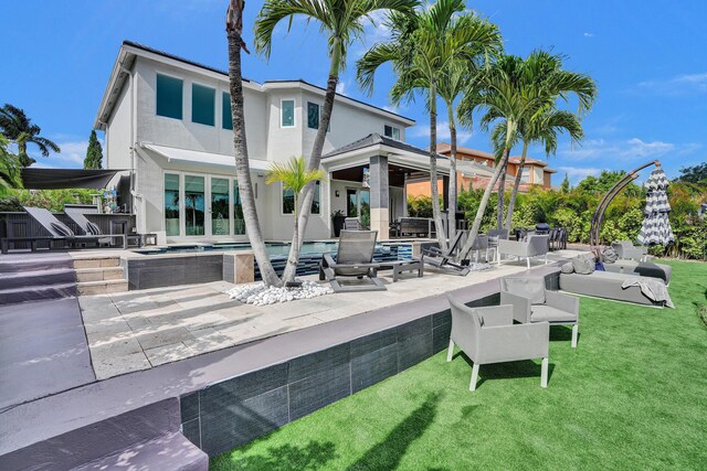 back of house with a jacuzzi, stucco siding, an outdoor pool, a patio area, and a lawn