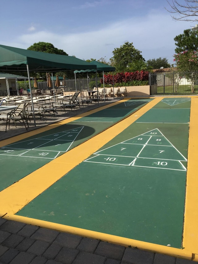 view of property's community featuring fence and shuffleboard