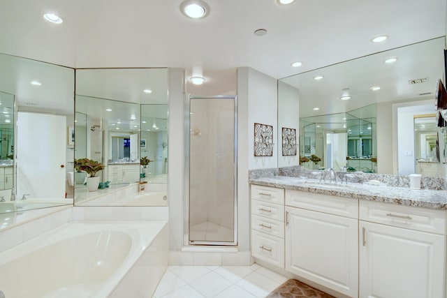 full bath with tile patterned floors, vanity, a garden tub, and a stall shower
