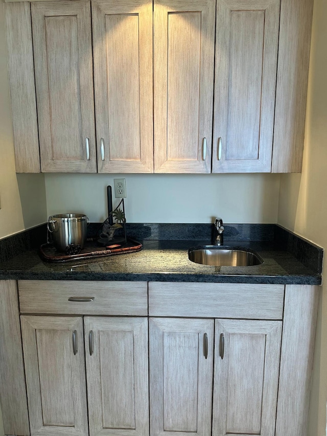 kitchen featuring dark stone countertops and a sink