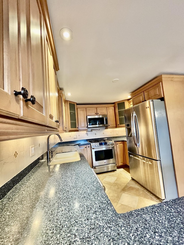 kitchen with recessed lighting, a sink, glass insert cabinets, backsplash, and appliances with stainless steel finishes