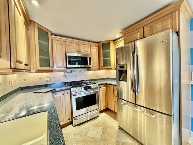 kitchen with backsplash, glass insert cabinets, and appliances with stainless steel finishes