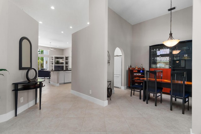 19699 Dinner Key Dr, Boca Raton, FL 33498 - dining room with a towering ceiling, baseboards, light tile patterned floors, a ceiling fan, and arched walkways
