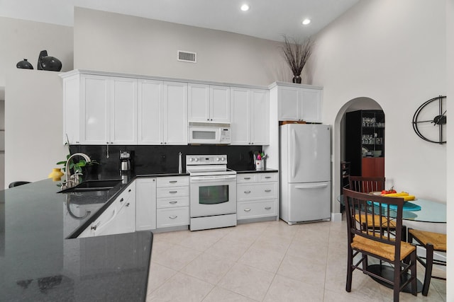 19699 Dinner Key Dr, Boca Raton, FL 33498 - kitchen with a sink, arched walkways, backsplash, and white appliances