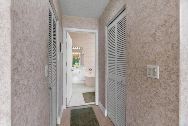 19699 Dinner Key Dr, Boca Raton, FL 33498 - corridor featuring wood finished floors and a textured ceiling