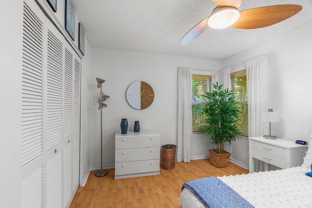 19699 Dinner Key Dr, Boca Raton, FL 33498 - bedroom featuring a textured ceiling, baseboards, light wood-style floors, a ceiling fan, and a closet