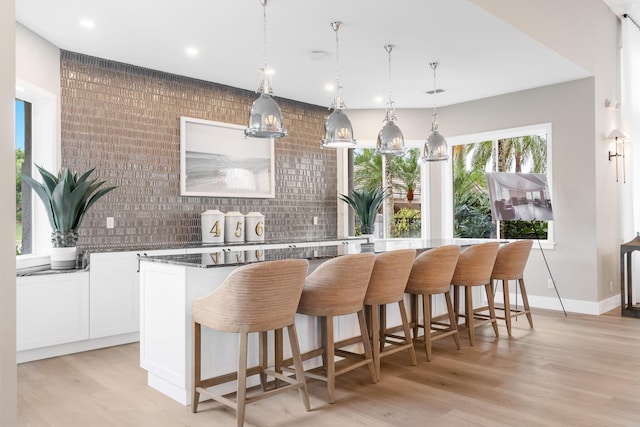 19699 Dinner Key Dr, Boca Raton, FL 33498 - interior space with light wood-type flooring, recessed lighting, backsplash, bar, and decorative light fixtures