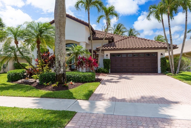 19699 Dinner Key Dr, Boca Raton, FL 33498 - mediterranean / spanish-style house with stucco siding, an attached garage, a tiled roof, and decorative driveway