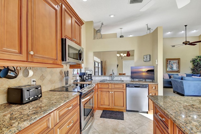 8326 Mooring Cir, Boynton Beach, FL 33472 - kitchen featuring stainless steel appliances, a sink, open floor plan, decorative backsplash, and light stone countertops