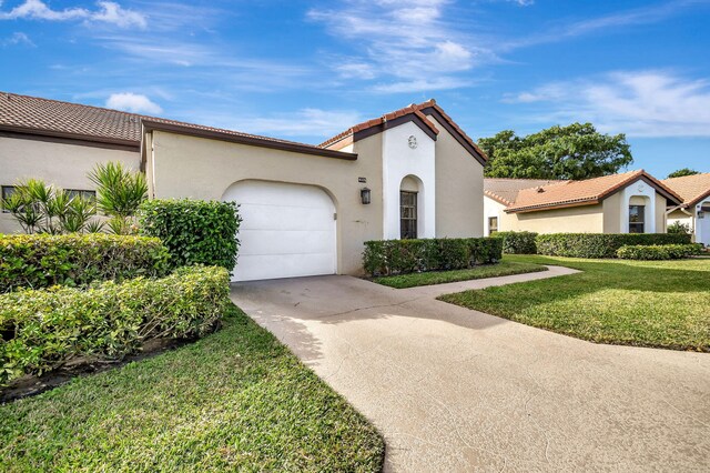 8326 Mooring Cir, Boynton Beach, FL 33472 - mediterranean / spanish-style house with driveway, an attached garage, stucco siding, a front yard, and a tiled roof