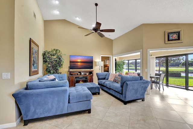8326 Mooring Cir, Boynton Beach, FL 33472 - living room featuring high vaulted ceiling, a ceiling fan, light tile patterned flooring, a lit fireplace, and baseboards