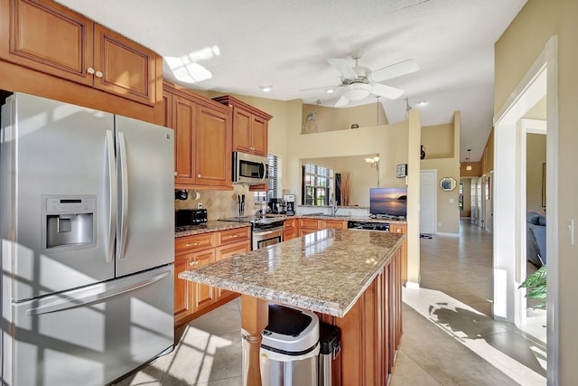 8326 Mooring Cir, Boynton Beach, FL 33472 - kitchen with appliances with stainless steel finishes, a sink, a kitchen island, ceiling fan, and light stone countertops